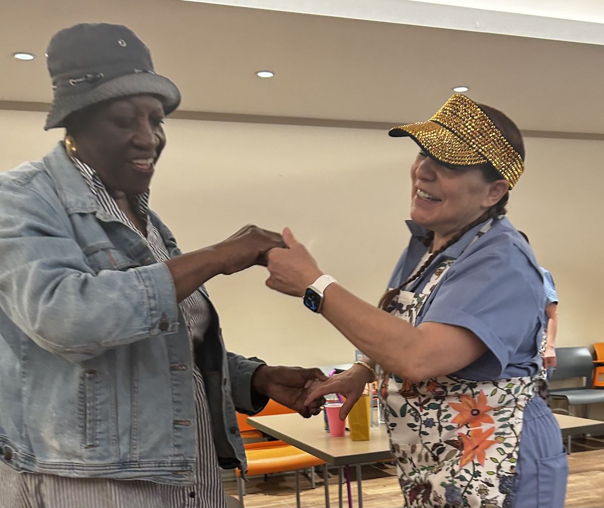 Two women holding hands and dancing together at a play date